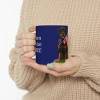 A ceramic mug featuring a Rottweiler sitting on grass, wearing a red, white, and blue bow tie, and holding an American flag against a dark blue background. with the message "Born to be Free"