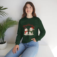 Woman wearing a green Christmas-themed sweatshirt with snowmen and 'Merry Christmas' text, sitting on a white surface with a plant in the background.
