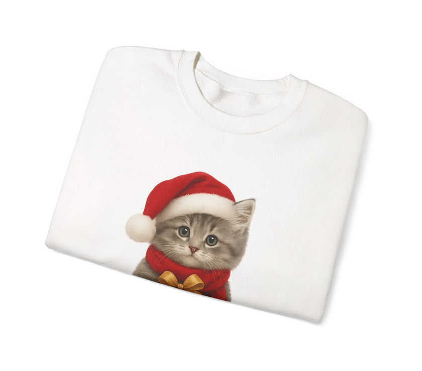White folded sweatshirt featuring a gray kitten wearing a Santa hat and red scarf, holding a small red gift box with a gold bow, surrounded by snowflake designs.