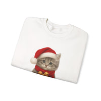 White folded sweatshirt featuring a gray kitten wearing a Santa hat and red scarf, holding a small red gift box with a gold bow, surrounded by snowflake designs.