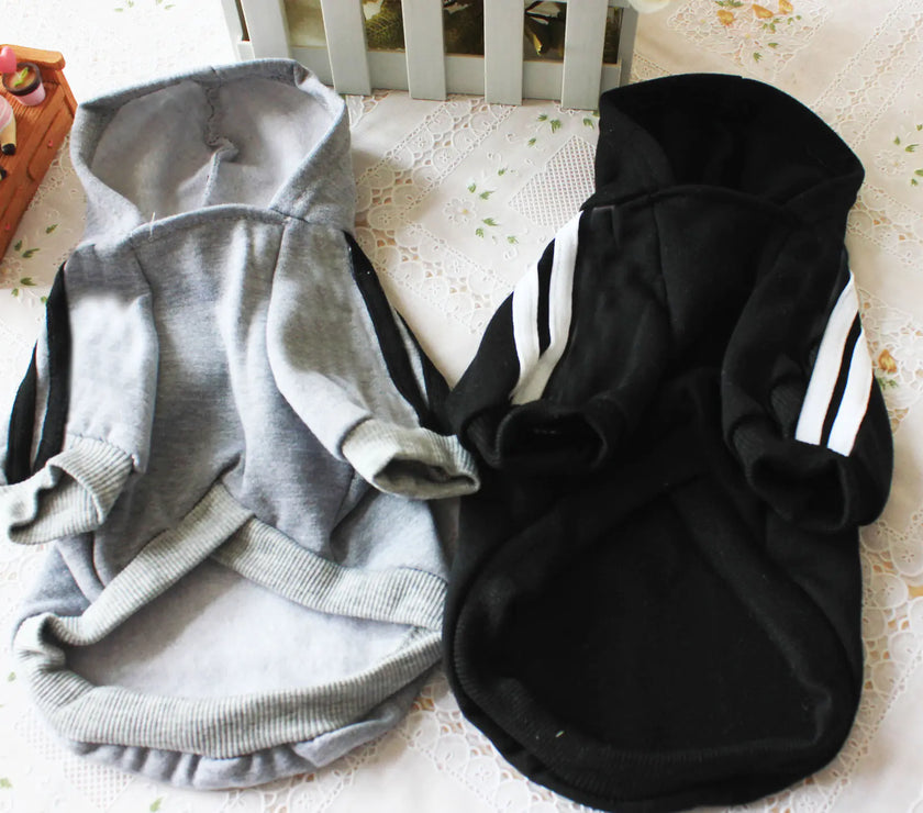 Gray and black pet hoodies with white stripes on a light surface