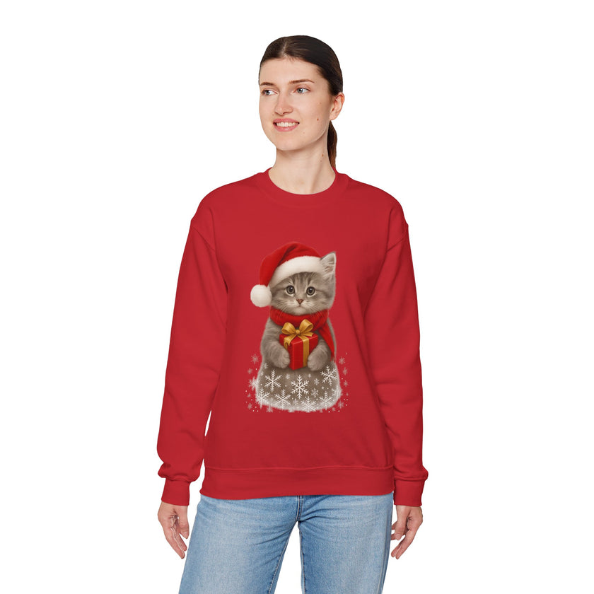Red sweatshirt featuring a gray kitten wearing a Santa hat and red scarf, holding a small red gift box with a gold bow, surrounded by snowflake designs.