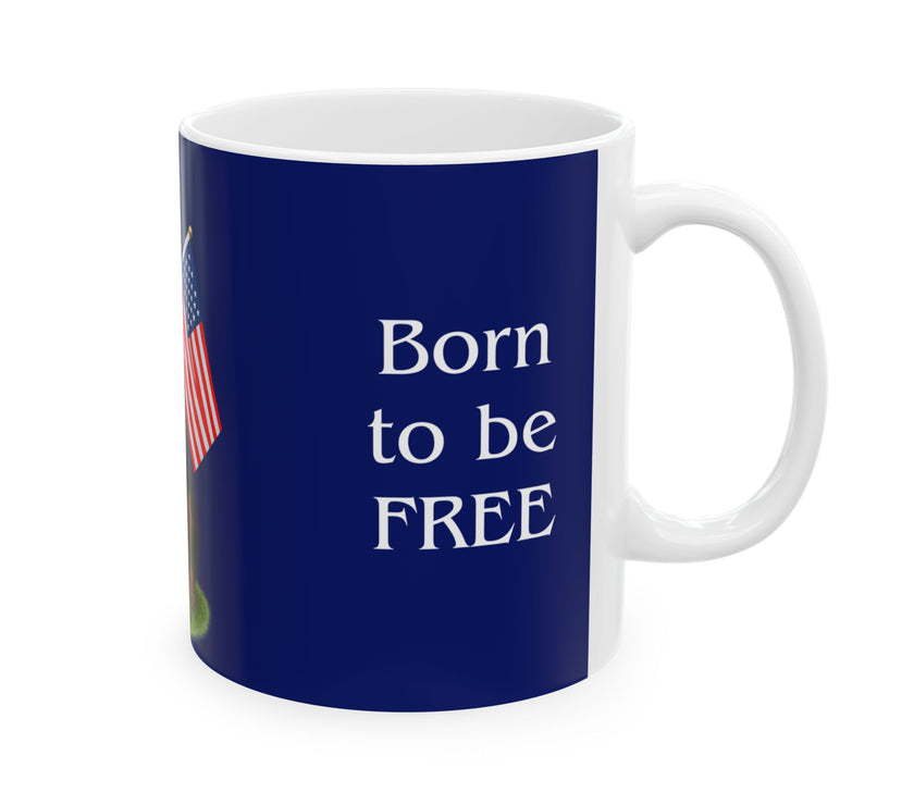 A ceramic mug featuring a Rottweiler sitting on grass, wearing a red, white, and blue bow tie, and holding an American flag against a dark blue background. with the message "Born to be Free"