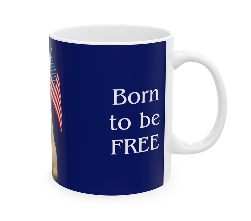 A ceramic mug featuring aGoldendoodle sitting on grass, wearing a red, white, and blue bow tie, and holding an American flag against a dark blue background. with the message "Born to be Free"  side view