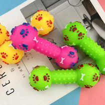 Colorful dog toys shaped like dumbbells on a magazine page.