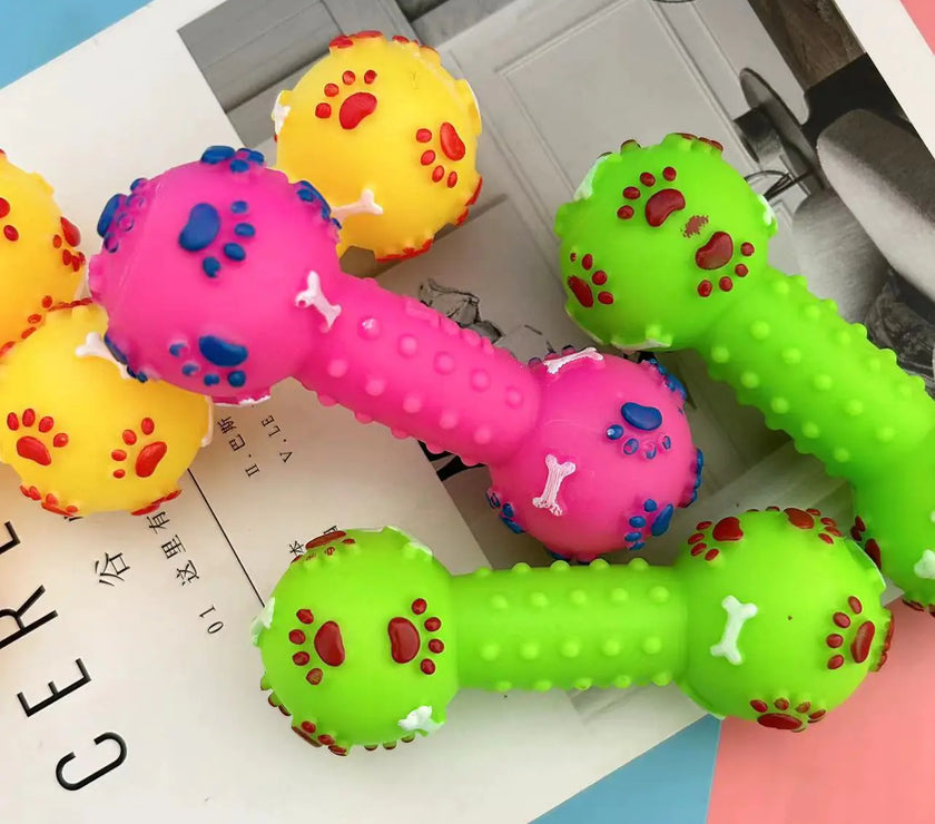 Colorful dog toys shaped like dumbbells on a magazine page.