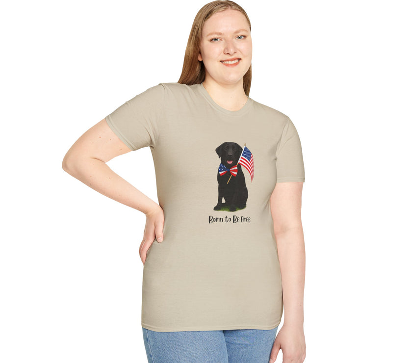 Sand t-shirt featuring a patriotic Black Lab wearing an American flag bowtie and holding U.S. flags, with the Black Labphrase "Born to Be Free" printed below — perfect for dog lovers and patriotic Americans.