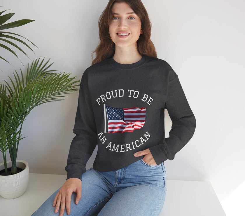 Person wearing a black sweatshirt with 'Proud to be an American' text and flag design, sitting indoors.