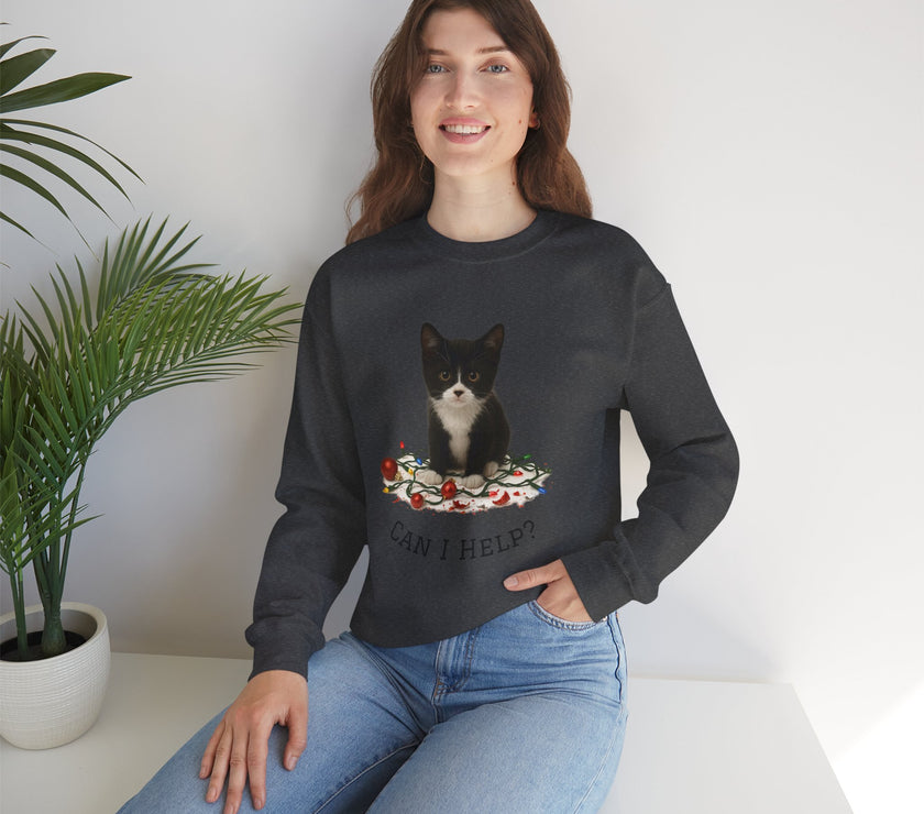 Woman wearing a black sweatshirt with a cat graphic and text, sitting on a white surface with a plant in the background.