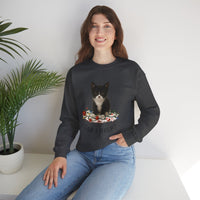 Woman wearing a black sweatshirt with a cat graphic and text, sitting on a white surface with a plant in the background.