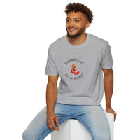 Man wearing a gray t-shirt with a graphic and text, sitting on a white stool against a white background.