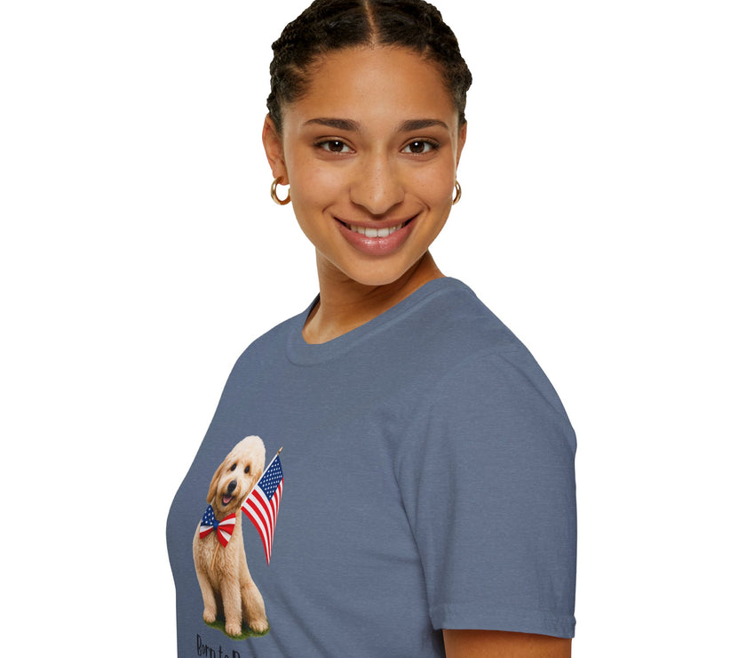 Female wearing T-shirt featuring a cute golden doodle puppy wearing an American flag bow tie and holding a small U.S. flag, with the phrase 'Born to Be Free' printed below the image.