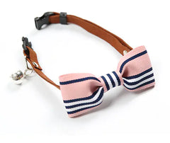 Cat collar with a pink and navy striped bow tie on a white background