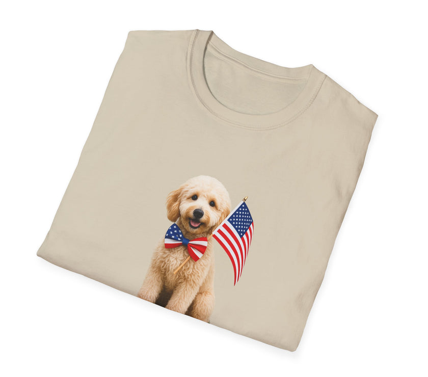 T-shirt featuring a cute golden doodle puppy wearing an American flag bow tie and holding a small U.S. flag, with the phrase 'Born to Be Free' printed below the image.  Folded