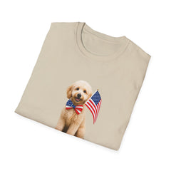 T-shirt featuring a cute golden doodle puppy wearing an American flag bow tie and holding a small U.S. flag, with the phrase 'Born to Be Free' printed below the image.  Folded