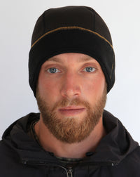 Man wearing a black beanie and dark jacket against a white background