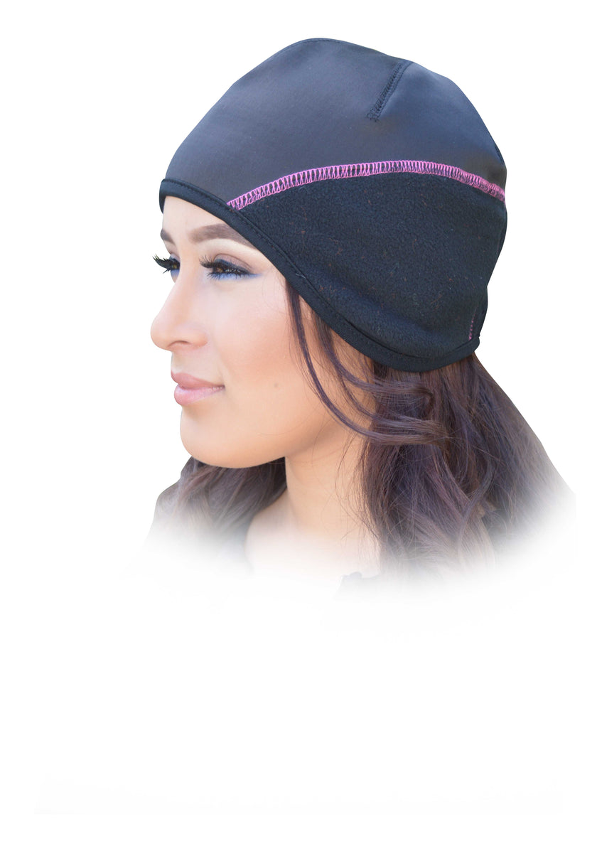 Woman wearing a black head cover with pink trim on a white background