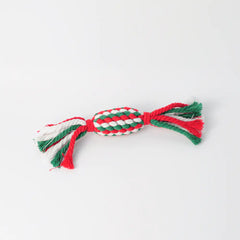 Red, green, and white braided dog toy on a light gray background