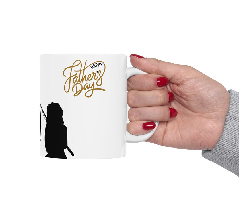 White ceramic mug featuring a silhouette of a child holding a fishing rod next to an adult figure, with the words "Happy Father's Day" in gold script above—an ideal gift for dads who love fishing and family time.