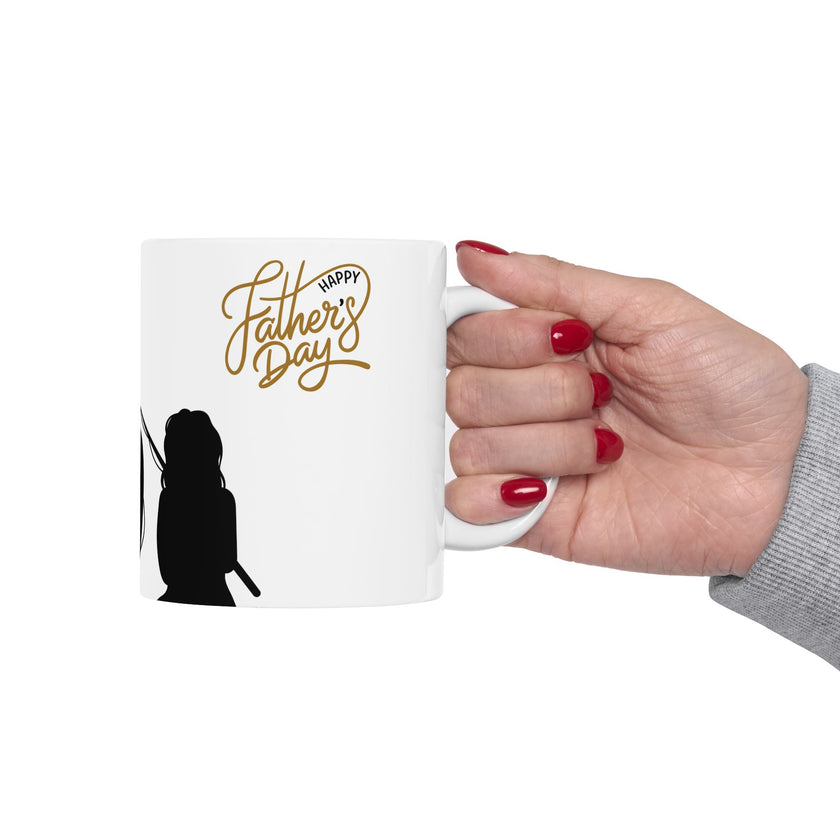 White ceramic mug featuring a silhouette of a child holding a fishing rod next to an adult figure, with the words "Happy Father's Day" in gold script above—an ideal gift for dads who love fishing and family time.