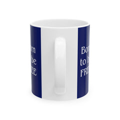 A ceramic mug featuring a Rottweiler sitting on grass, wearing a red, white, and blue bow tie, and holding an American flag against a dark blue background. with the message "Born to be Free"