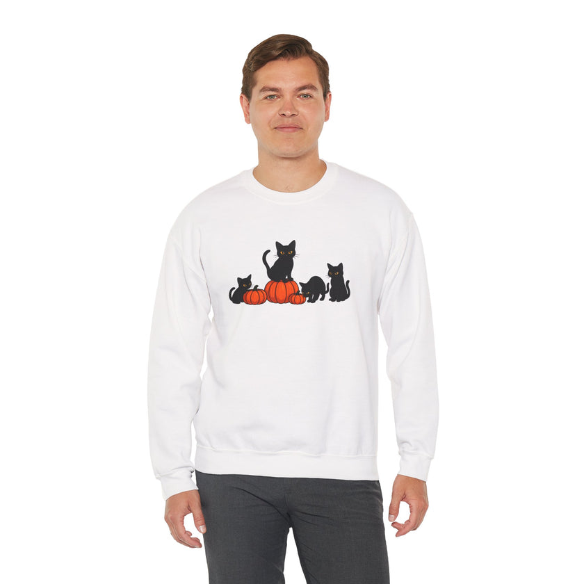 Person wearing a white sweatshirt with black cat and orange pumpkin design on a white background