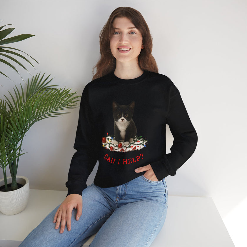 Woman wearing a black sweatshirt with a cat graphic and text, sitting on a white surface with a plant in the background.
