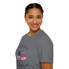 Smiling woman  wearing a white t-shirt with an American flag graphic and the words 'Proud to Be an American' printed around the flag