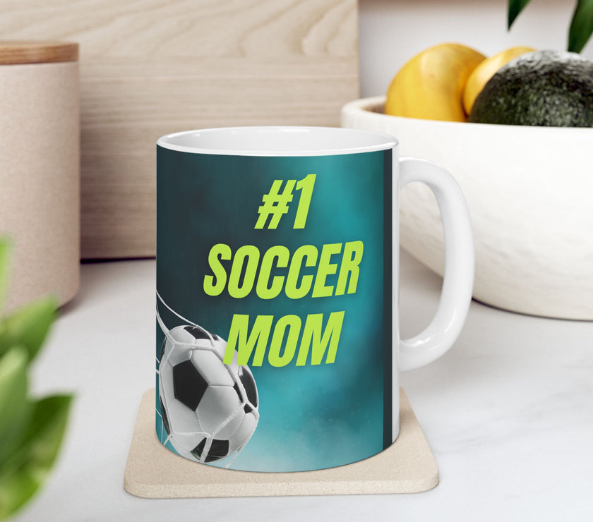Mug with '#1 Soccer Mom' text and soccer ball design on a teal background