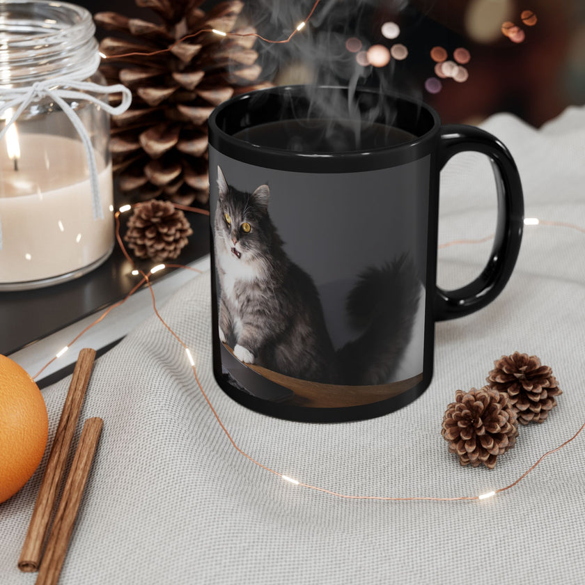 Black ceramic mug featuring a cartoon-style image of a cat sitting at a computer with the funny quote “I work hard so my cat can have a better life.”