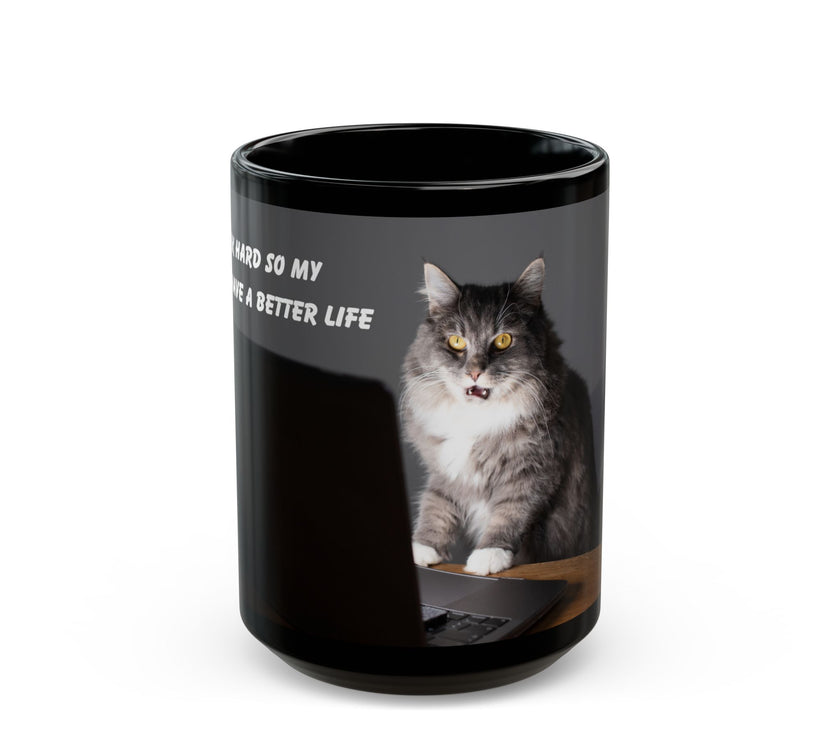 Black ceramic mug featuring a cartoon-style image of a cat sitting at a computer with the funny quote “I work hard so my cat can have a better life.”