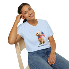 Female wearing T-shirt featuring a cute golden doodle puppy wearing an American flag bow tie and holding a small U.S. flag, with the phrase 'Born to Be Free' printed below the image.