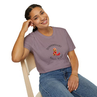 Person wearing a purple t-shirt with a graphic and text, sitting on a chair.