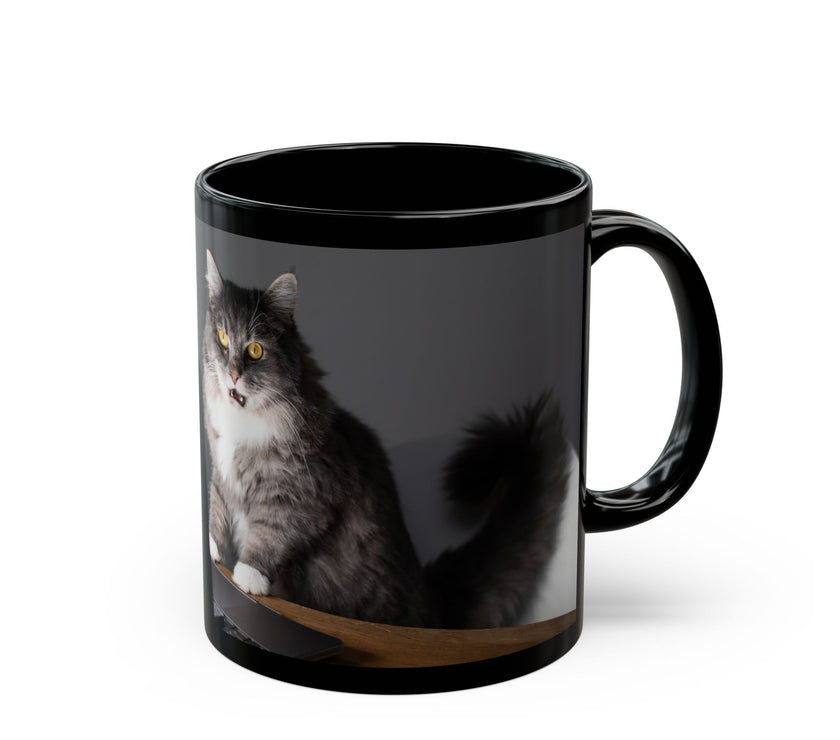 Black ceramic mug featuring a cartoon-style image of a cat sitting at a computer with the funny quote “I work hard so my cat can have a better life.”