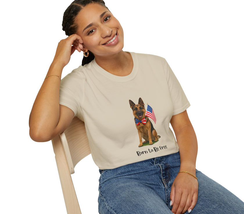 Beige t-shirt featuring a patriotic German Shepherd wearing an American flag bowtie and holding U.S. flags, with the phrase "Born to Be Free" printed below — perfect for dog lovers and patriotic Americans.