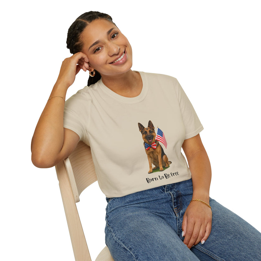 Beige t-shirt featuring a patriotic German Shepherd wearing an American flag bowtie and holding U.S. flags, with the phrase "Born to Be Free" printed below — perfect for dog lovers and patriotic Americans.