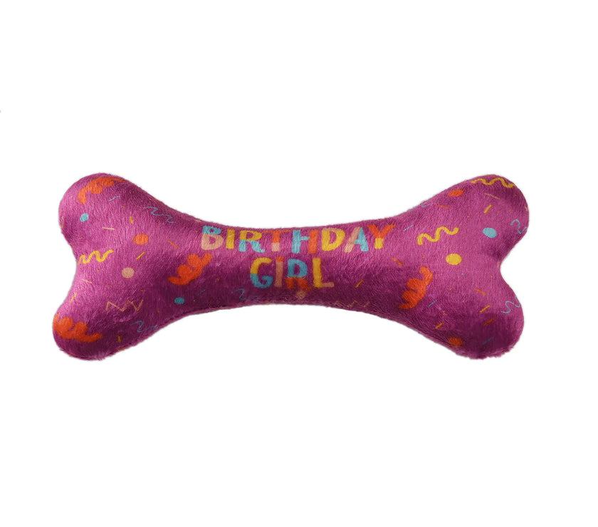 Pink bone-shaped toy with 'Birthday Girl' text on a white background