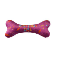 Pink bone-shaped toy with 'Birthday Girl' text on a white background