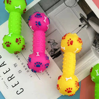 Colorful dog toys shaped like dumbbells on a magazine with visible text.