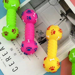 Colorful dog toys shaped like dumbbells on a magazine with visible text.
