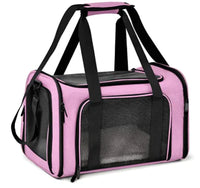 Pink pet carrier with black interior and straps on a white background