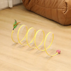 Spring toy with feather and ball on a wooden floor