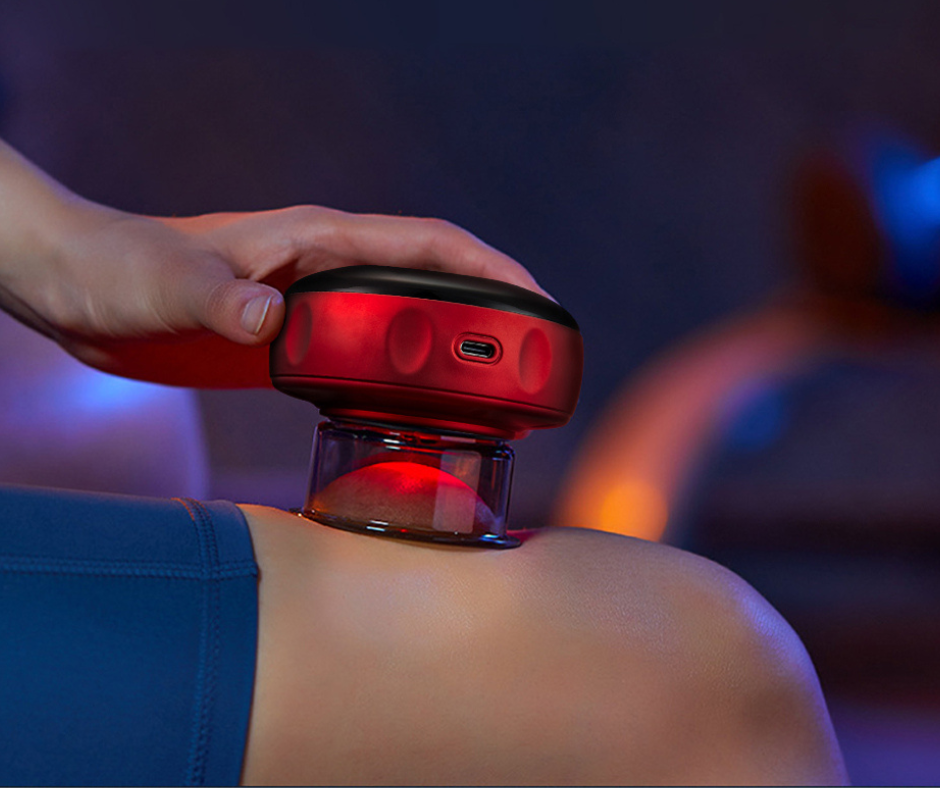 Person using a red light device on their shoulder against a dark background