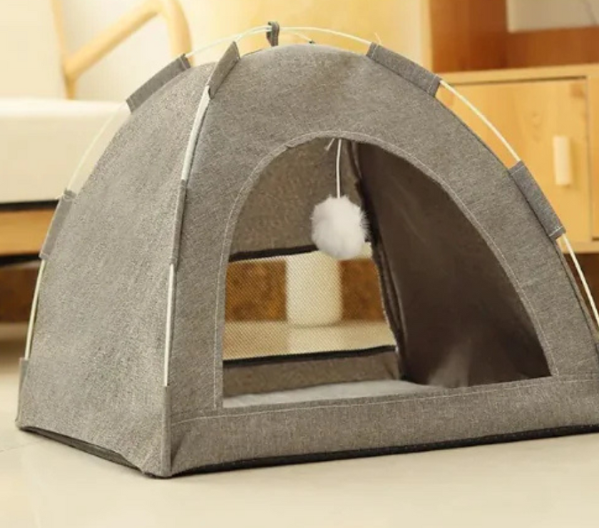 Gray pet tent with a fluffy white ball inside on a light-colored floor.