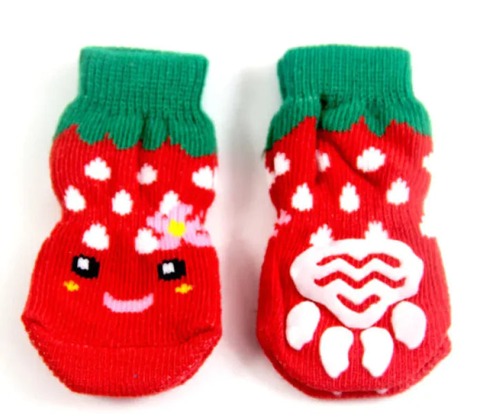Red strawberry-themed pet socks with green tops on a white background