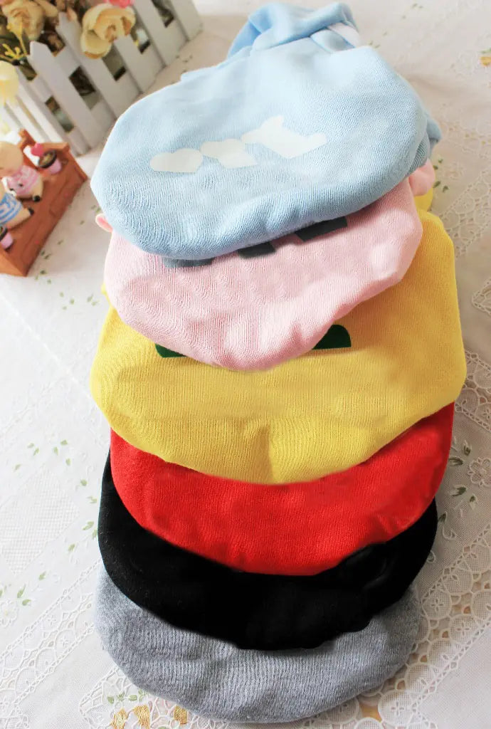 Stack of colorful baby bibs on a textured surface