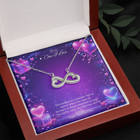 Silver infinity heart necklace displayed in a gift box on a purple Valentine-themed background symbolizing endless love.
