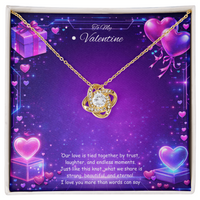 Gold love knot necklace with a sparkling center stone displayed on a purple Valentine’s Day background with glowing hearts, symbolizing eternal love and romantic connection.