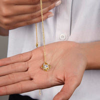 Gold love knot necklace with a sparkling center stone, symbolizing eternal love and romantic connection.