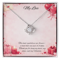Silver love knot necklace with a sparkling center stone  on a soft Valentine-themed background with hearts and romantic message card.